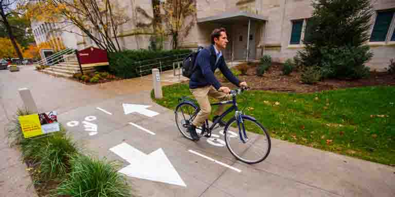A person rides a bike on the IU campus.