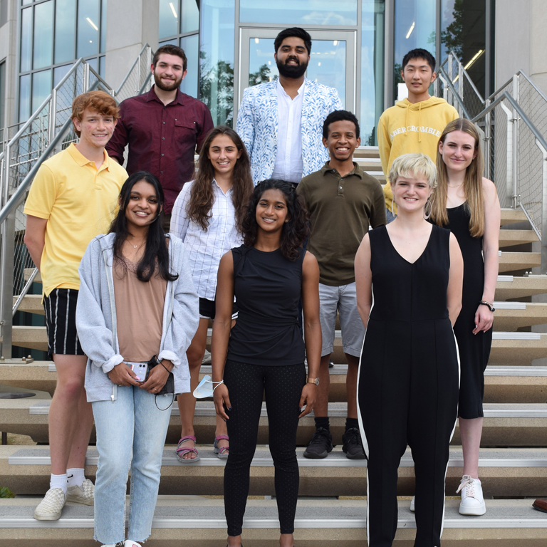 The 2021-22 Shoemaker Scholars stand on steps to pose for a photo.