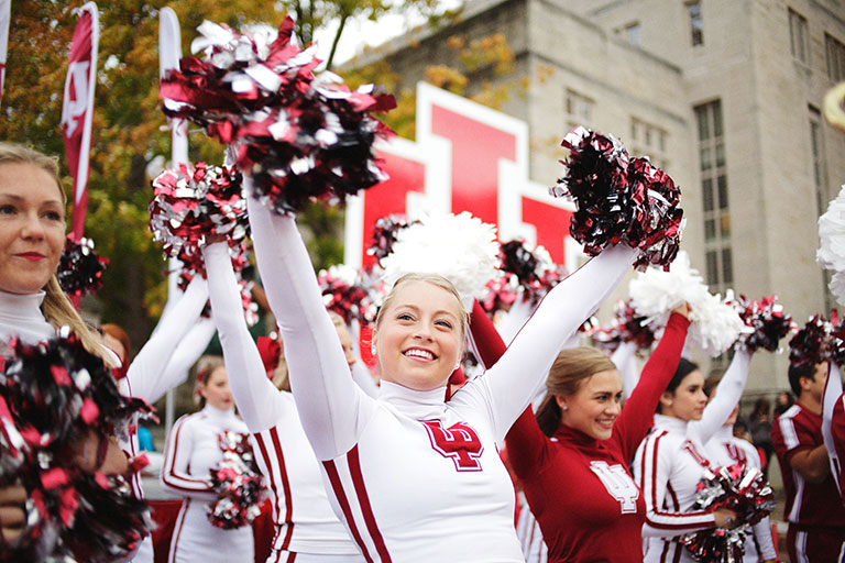 Cheerleaders cheer at a pep rally in front of the Sample Gates.